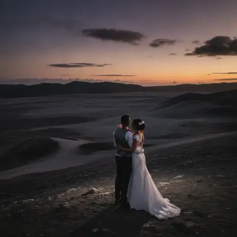 Les mariés enlacés devant un paysage volcanique au crépuscule